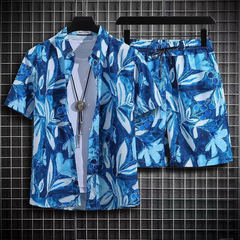 Completo estivo uomo, camicia e pantaloncini blu con motivo floreale, appesi su grucce. Moda casual, abbigliamento leggero, stile vacanza.