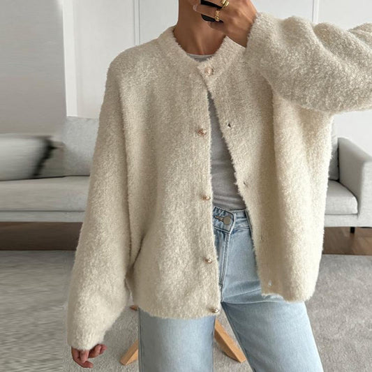 Giacca in lana bouclé beige, abbottonata, indossata con jeans chiari. Stile casual e moderno, perfetto per l'autunno.