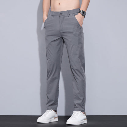 Pantaloni grigi da uomo eleganti, indossati con scarpe bianche e orologio, moda casual, abbigliamento maschile moderno.