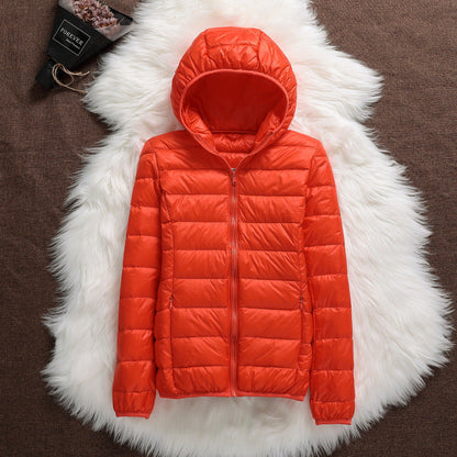 Giacca piumino arancione con cappuccio su sfondo di pelliccia bianca, moda invernale, abbigliamento caldo, stile casual, tendenza autunno inverno.
