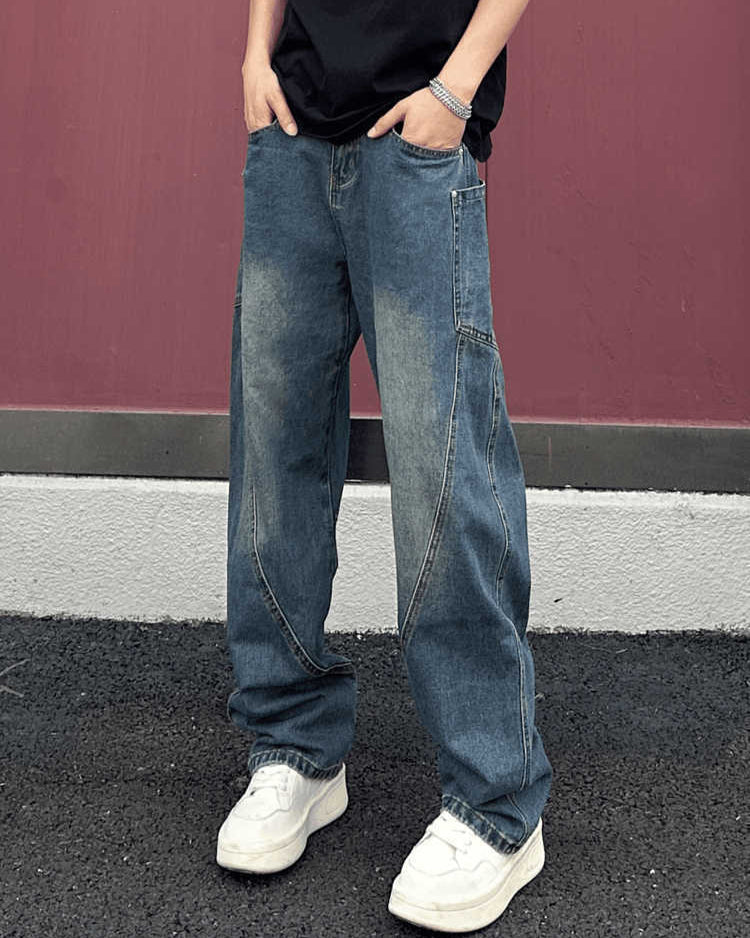 Jeans larghi da uomo, stile casual, indossati con scarpe bianche su sfondo rosso. Moda streetwear, pantaloni denim ampi, tendenza giovanile.