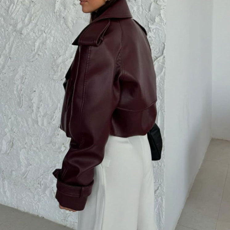 Giacca in pelle bordeaux su sfondo bianco, indossata da una persona di profilo. Moda autunnale, stile elegante, tendenze abbigliamento 2023.