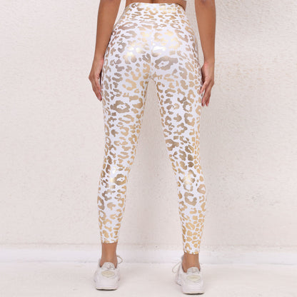 Leggings sportivi donna a vita alta con stampa leopardata bianca e dorata, indossati con scarpe da ginnastica bianche su sfondo neutro.