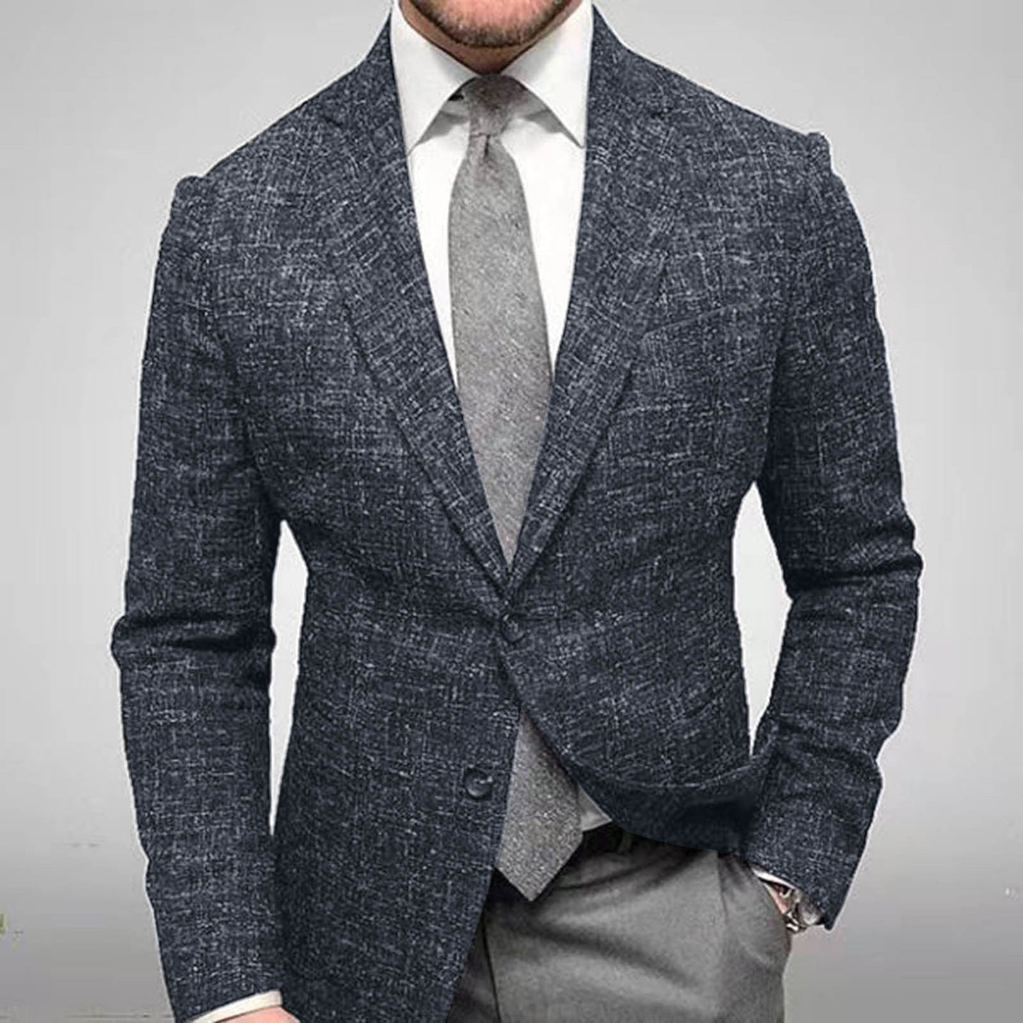 Uomo in elegante abito grigio scuro, giacca a quadri, camicia bianca e cravatta grigia. Moda maschile, abbigliamento formale, stile business.