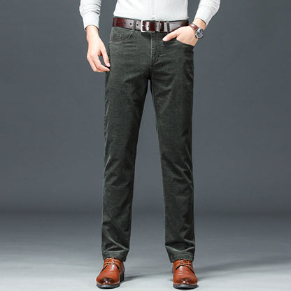 Pantaloni uomo in velluto a coste grigio scuro, abbinati a cintura marrone e scarpe eleganti. Moda maschile autunno inverno, stile casual chic.