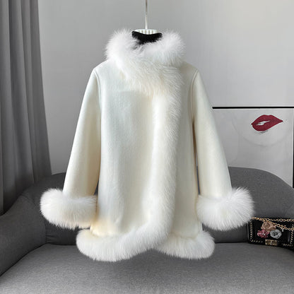 Cappotto bianco in lana con bordi in pelliccia sintetica, appeso su un manichino. Elegante e caldo, ideale per l'inverno. Moda donna.