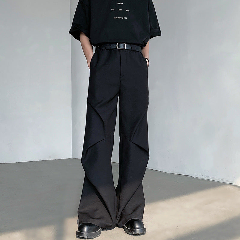 Pantaloni neri a zampa d'elefante, stile casual, con cintura e scarpe nere. Moda uomo contemporanea, abbigliamento urbano elegante.