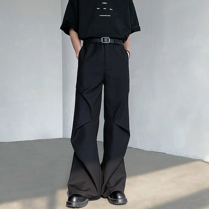 Pantaloni neri a zampa d'elefante, stile casual, con cintura e scarpe nere. Moda uomo contemporanea, abbigliamento urbano elegante.