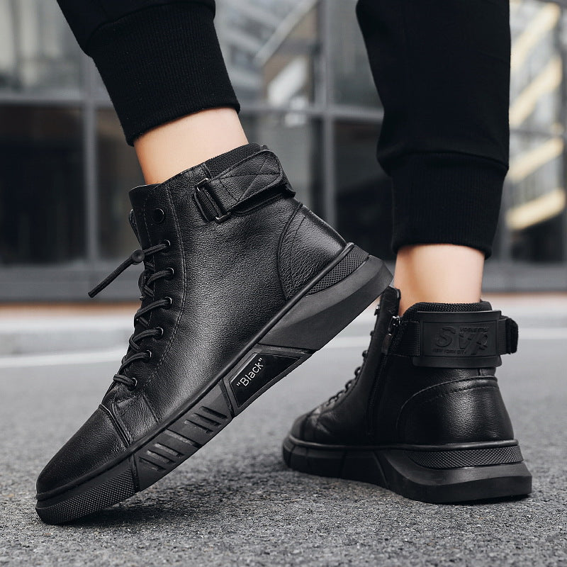 Scarpe da ginnastica alte nere in pelle, design moderno con lacci e cinturino alla caviglia, suola robusta, indossate su strada urbana.
