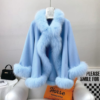 Cappotto azzurro in lana con bordi in pelliccia sintetica, appeso su sedia bianca. Elegante e caldo, ideale per moda invernale.