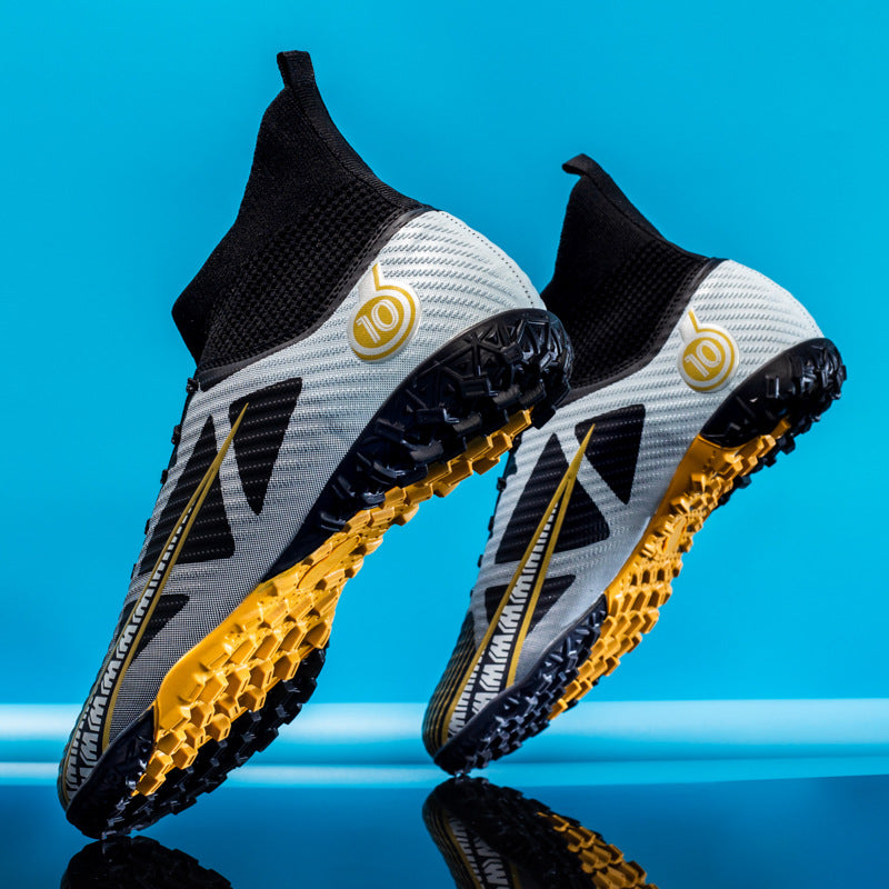 Scarpe da calcio grigie e nere con dettagli gialli su sfondo blu, design moderno, suola antiscivolo, ideali per prestazioni sportive elevate.