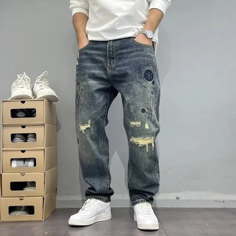 Uomo con jeans strappati e scarpe bianche, accanto a scatole di scarpe impilate. Moda casual, abbigliamento streetwear, tendenze denim.