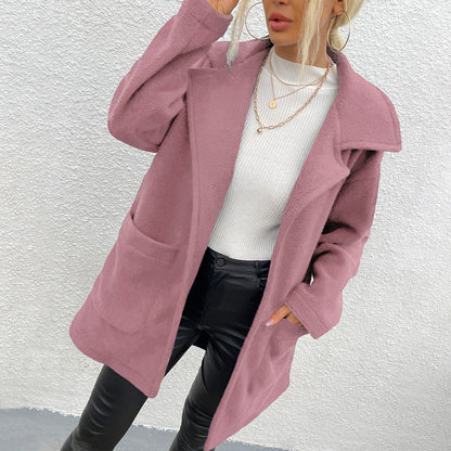 Donna con cappotto rosa elegante, maglione bianco e pantaloni in pelle nera. Moda autunnale, stile casual chic, tendenze abbigliamento femminile.