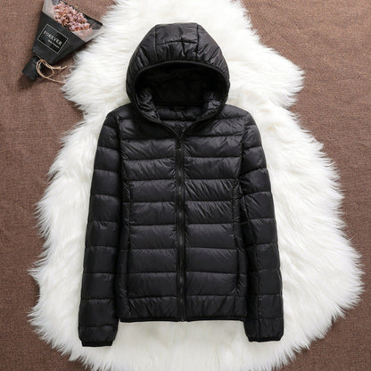 Giacca invernale nera con cappuccio su sfondo bianco peloso, moda abbigliamento caldo, piumino leggero, stile casual, tendenza autunno inverno.