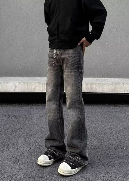 Jeans larghi grigi vintage, scarpe da ginnastica bianche e nere, felpa nera; moda streetwear casual, tendenze abbigliamento urbano.