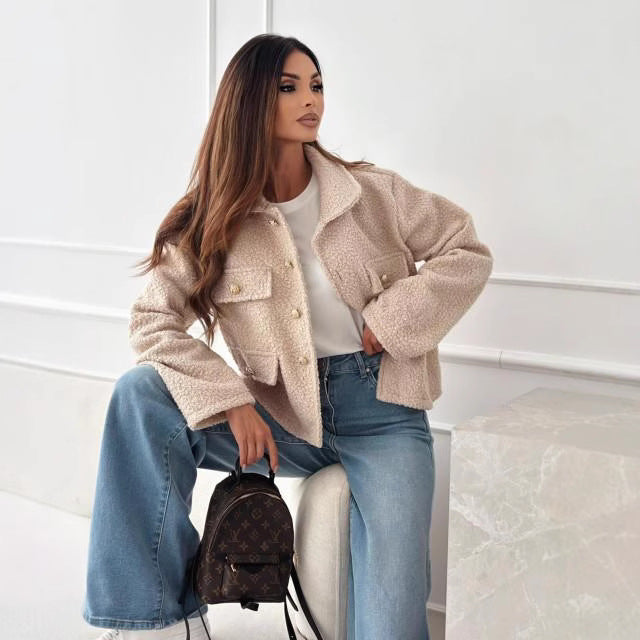 Donna con giacca in lana beige, jeans a zampa e zaino marrone. Moda autunnale elegante, stile casual chic. Sfondo bianco minimalista.