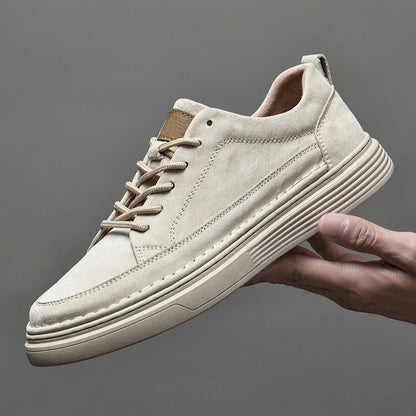 Scarpa da ginnastica beige in pelle scamosciata, suola spessa, design moderno, tenuta in mano. Scarpe casual uomo, moda urbana, comfort.