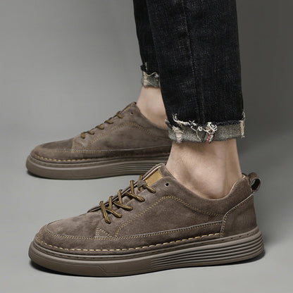 Scarpe da ginnastica marroni in pelle scamosciata, suola spessa, indossate con jeans neri. Design casual e moderno, perfette per l'autunno.