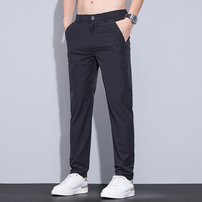 Pantaloni eleganti da uomo neri, vestibilità slim, con tasche laterali, abbinati a scarpe bianche casual. Ideali per look formale e casual.