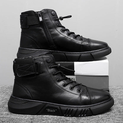 Scarpe da ginnastica alte nere in pelle con lacci e cerniera laterale, suola robusta, su scatola bianca e grigia. Scarpe moda uomo casual.