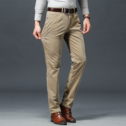 Uomo in pantaloni beige eleganti, camicia grigia e scarpe marroni su sfondo grigio. Moda maschile, abbigliamento casual chic, stile autunnale.