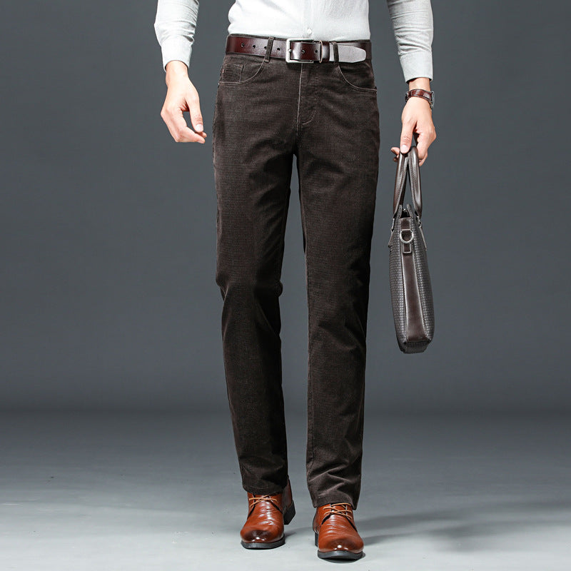 Uomo in pantaloni di velluto marrone scuro, camicia bianca, scarpe eleganti marroni, con borsa in pelle nera. Moda maschile autunno inverno.
