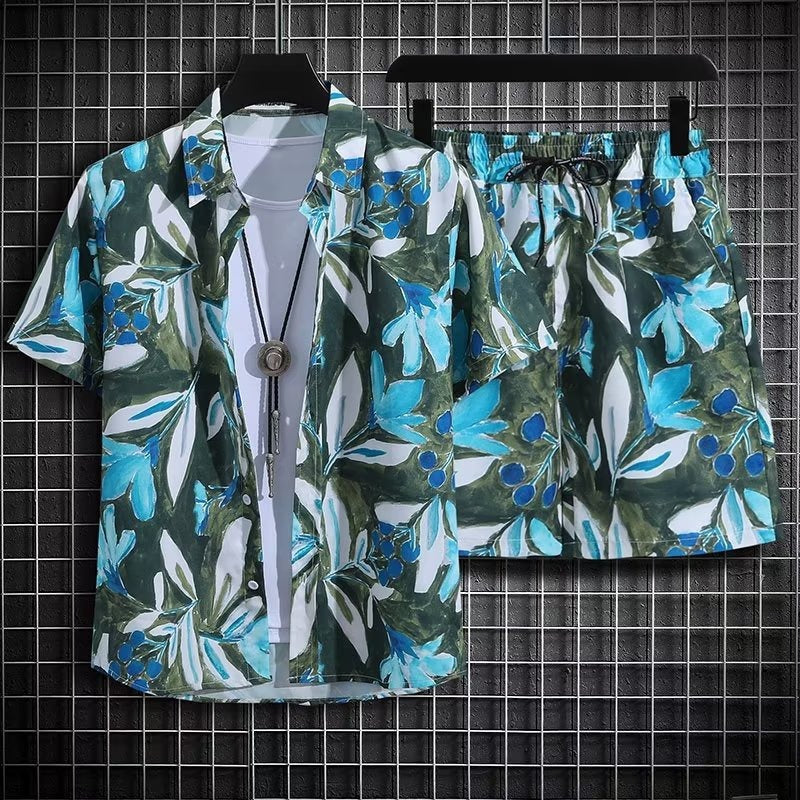 Completo estivo uomo con camicia e pantaloncini a fantasia tropicale verde e blu, appeso su grucce nere, sfondo a griglia.