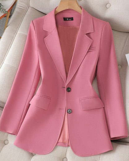 Giacca blazer rosa elegante da donna su appendiabiti, con due bottoni e tasche frontali, su sfondo chiaro. Moda femminile, abbigliamento formale.