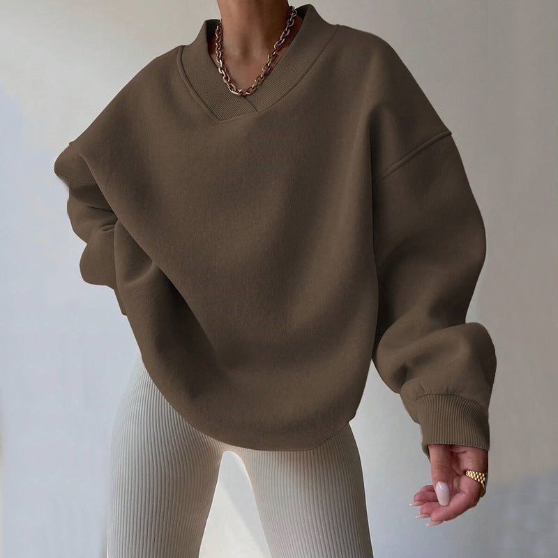 Donna con maglione oversize marrone e pantaloni a coste bianchi. Moda autunnale, stile casual, tendenze abbigliamento femminile 2023.
