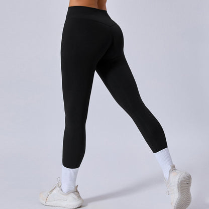 Donna in leggings neri sportivi, scarpe da ginnastica bianche e calzini alti. Abbigliamento fitness, moda attiva, comfort e stile.