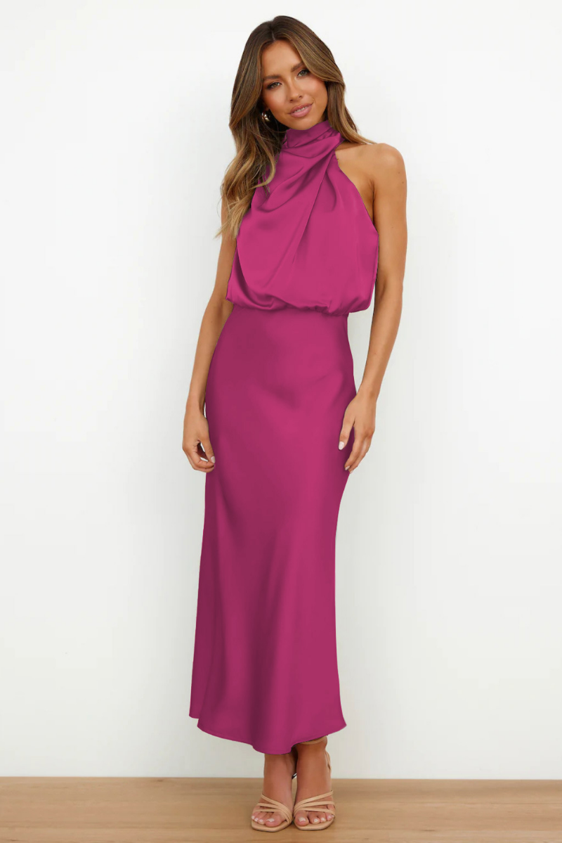 Abito lungo fucsia elegante, senza maniche, con collo alto drappeggiato. Perfetto per eventi formali e serate glamour.