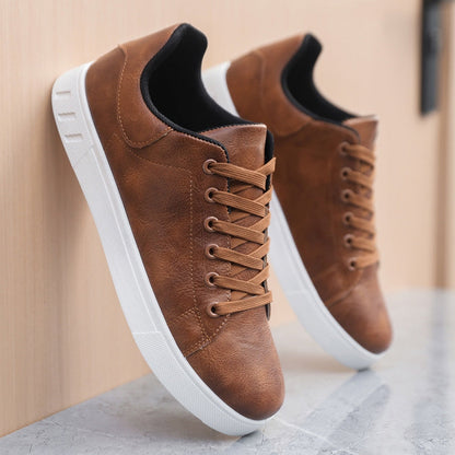 Scarpe da ginnastica in pelle marrone con suola bianca, design moderno, lacci coordinati, appoggiate su superficie di marmo. Scarpe casual eleganti.