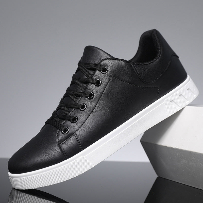 Scarpa da ginnastica nera in pelle sintetica con suola bianca, design moderno, lacci neri, ideale per moda casual e streetwear.