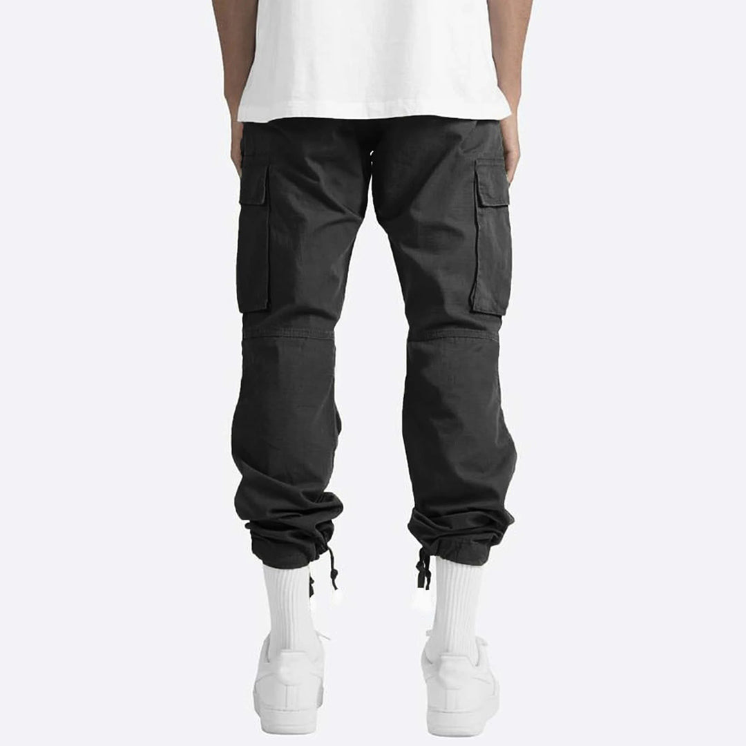 Pantaloni cargo neri da uomo, tasche laterali, vestibilità comoda, abbinati a calzini bianchi e scarpe sportive, moda casual urbana.