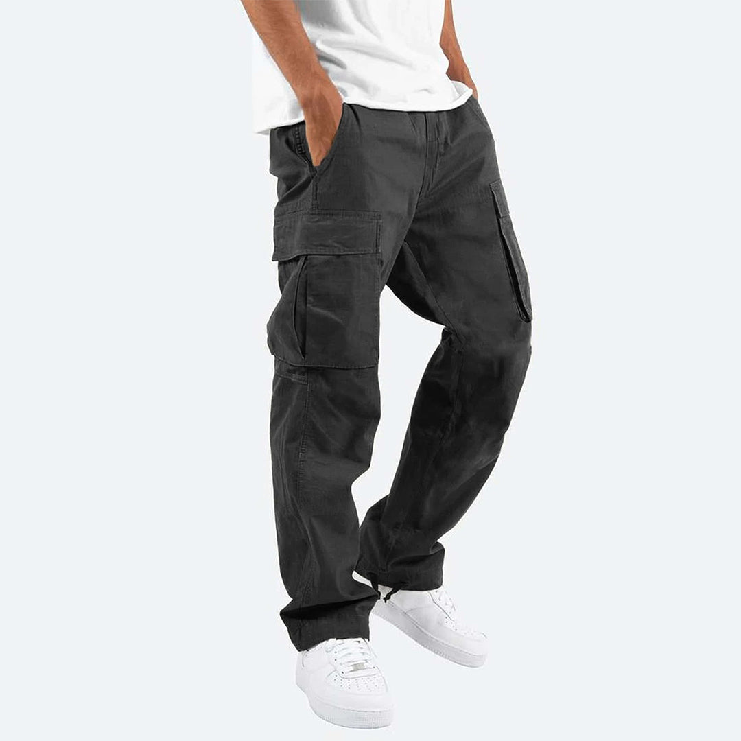 Pantaloni cargo neri da uomo, tasche multiple, stile casual, abbinati a scarpe bianche e maglietta bianca, moda streetwear.