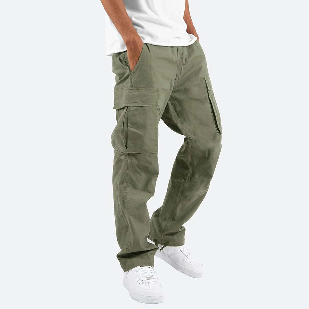 Pantaloni cargo verde oliva da uomo, tasche multiple, stile casual, abbinati a scarpe bianche e maglietta bianca. Moda maschile contemporanea.