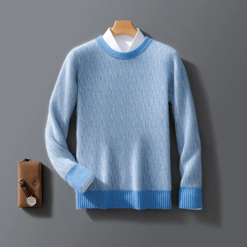 Maglione azzurro in cashmere su gruccia, con camicia bianca sotto, accanto a portafoglio marrone e orologio. Elegante abbigliamento invernale uomo.