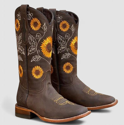 Stivali da cowboy marroni con ricami di girasoli gialli, suola in cuoio, design floreale, moda western, calzature artigianali eleganti.