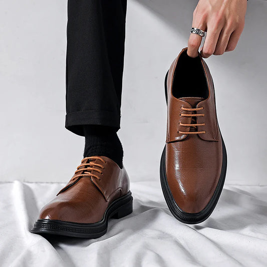 Scarpe eleganti in pelle marrone con lacci, indossate da una persona con pantaloni neri. Scarpe da uomo classiche, moda formale.