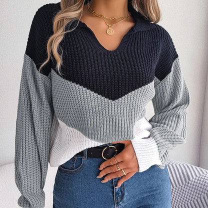 Donna con maglione a righe blu, grigio e bianco, jeans a vita alta, collana dorata e anelli. Moda autunnale, abbigliamento casual elegante.