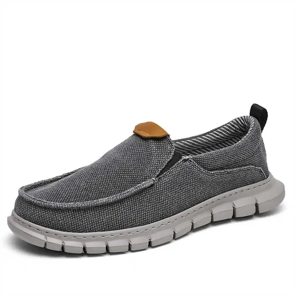 Scarpa casual grigia da uomo, tessuto traspirante, suola in gomma bianca, design slip-on, ideale per comfort quotidiano e stile urbano.