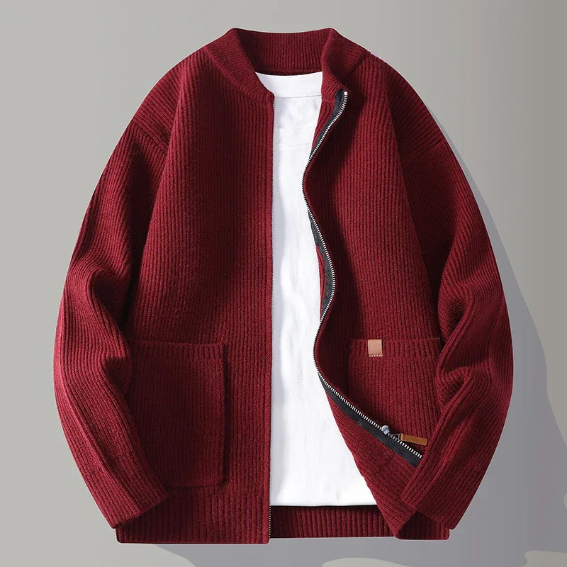 Giacca cardigan uomo in maglia rosso bordeaux con zip aperta, tasche frontali, su sfondo grigio. Moda autunno inverno, abbigliamento casual elegante.