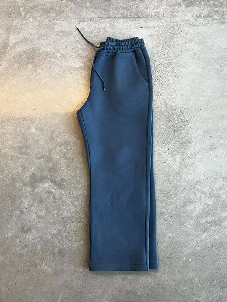 Pantaloni tuta blu su sfondo grigio, moda casual, abbigliamento sportivo, tessuto morbido, stile comodo, pantaloni elastici con coulisse.