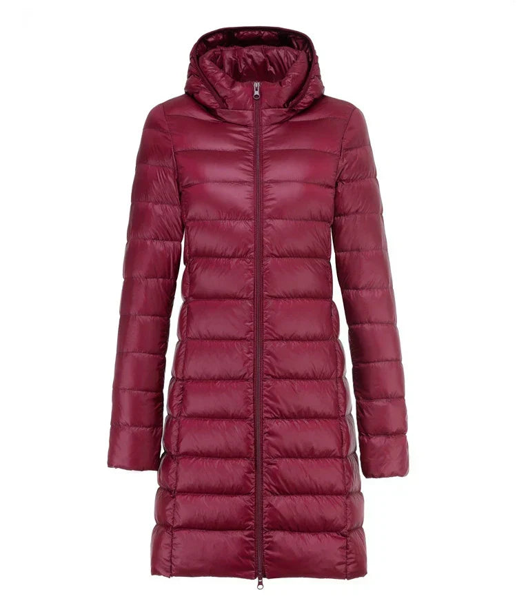 Piumino lungo donna bordeaux con cappuccio, chiusura zip frontale. Giacca invernale elegante e calda, ideale per la stagione fredda.