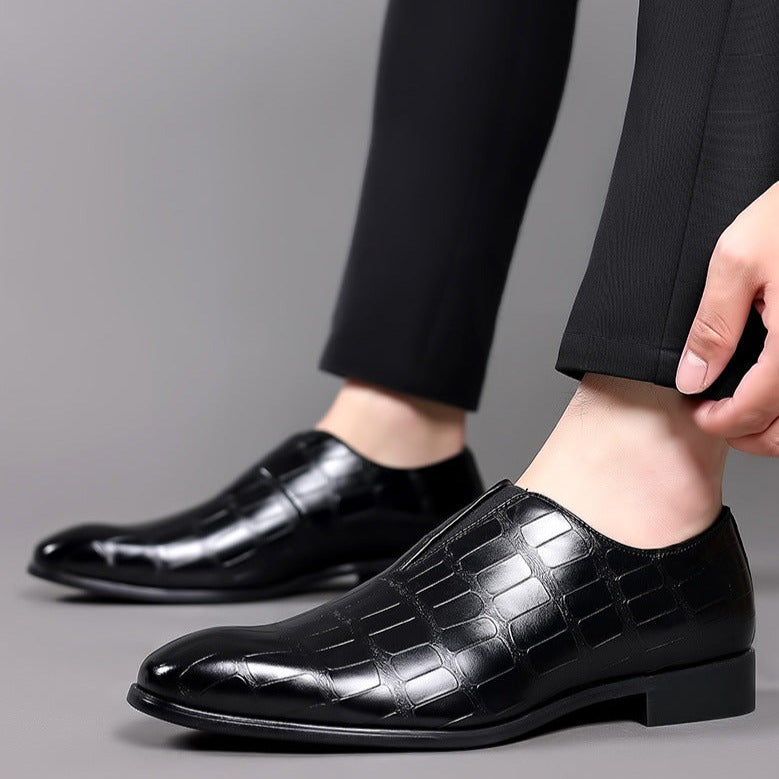 Scarpe eleganti uomo in pelle nera lucida, design a quadri, indossate con pantaloni neri. Calzature formali di lusso per occasioni speciali.