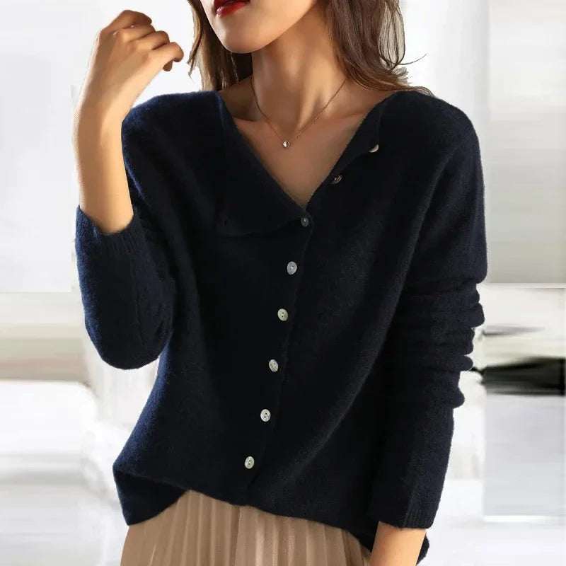 Donna indossa maglione blu scuro con bottoni, stile casual elegante, collana sottile, sfondo sfocato. Moda autunnale, abbigliamento femminile trendy.