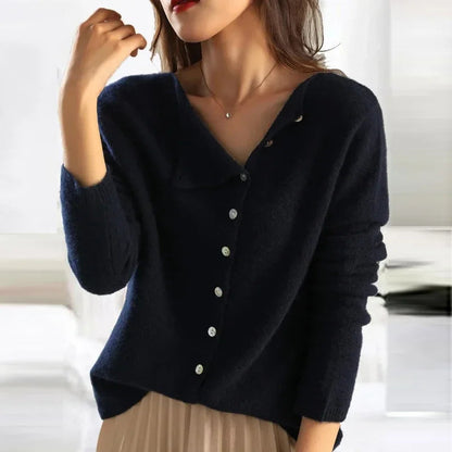 Donna indossa maglione blu scuro con bottoni, stile casual elegante, collana sottile, sfondo sfocato. Moda autunnale, abbigliamento femminile trendy.