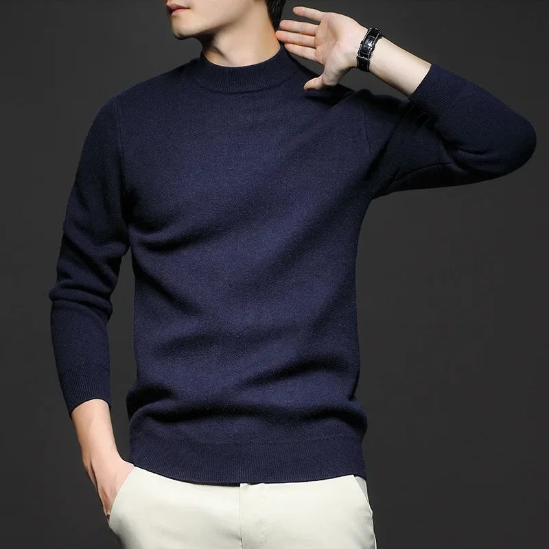 Maglione uomo blu scuro a collo alto, indossato con pantaloni chiari. Stile elegante e moderno, ideale per moda autunnale e invernale.