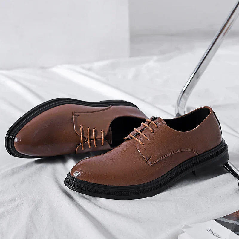 Scarpe eleganti da uomo in pelle marrone, con lacci, suola nera, su sfondo bianco. Scarpe formali, moda maschile, calzature classiche.