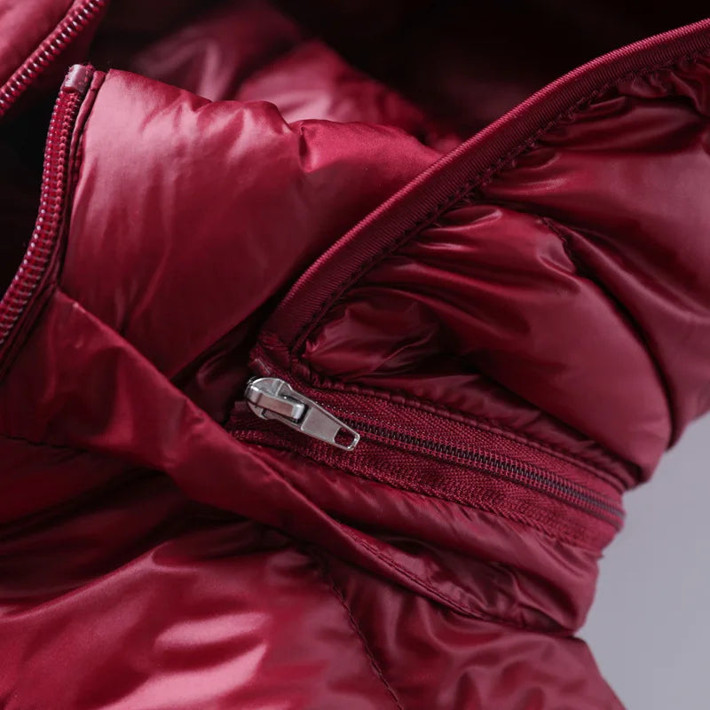 Giacca invernale imbottita rossa con cerniera, tessuto lucido, dettaglio del colletto. Moda inverno, abbigliamento caldo, giacca trapuntata.
